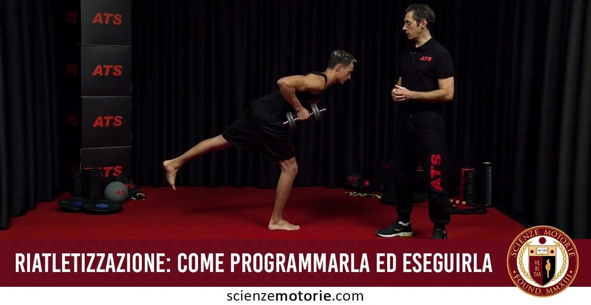 Due persone in palestra. Una solleva un manubrio piegandosi in avanti, mentre l'altra osserva e dà istruzioni. Attrezzi da palestra come pesi e scatole sono visibili sul lato sinistro. Il pavimento è coperto da un tappeto rosso e le tende nere creano lo sfondo. In basso, c'è il testo "Riatletizzazione: come programmarla ed eseguirla" con il logo di Scienze Motorie
