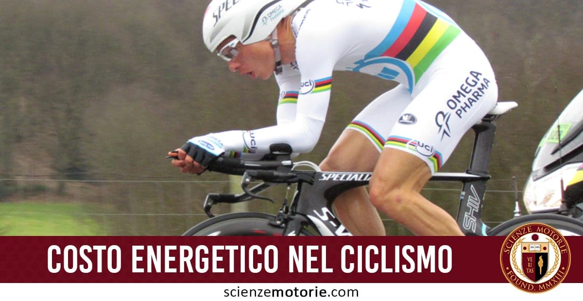 Ciclista in posizione aerodinamica su bici da corsa, con casco e abbigliamento tecnico a strisce colorate; in basso il testo "Costo energetico nel ciclismo" e il logo ScienzeMotorie.com su sfondo sfocato.