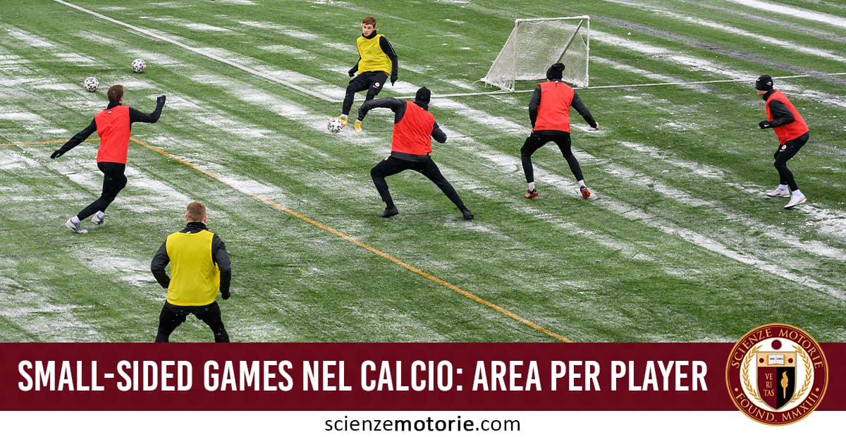 Calciatori adulti durante un allenamento di calcio a campo ridotto invernale, con pettorine rosse e gialle su campo sintetico con brina.